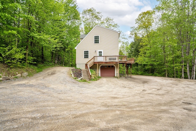 15 Convene Rd, Sebago, ME 04029 - view of front of house featuring dirt driveway, stairway, a deck, and an attached garage