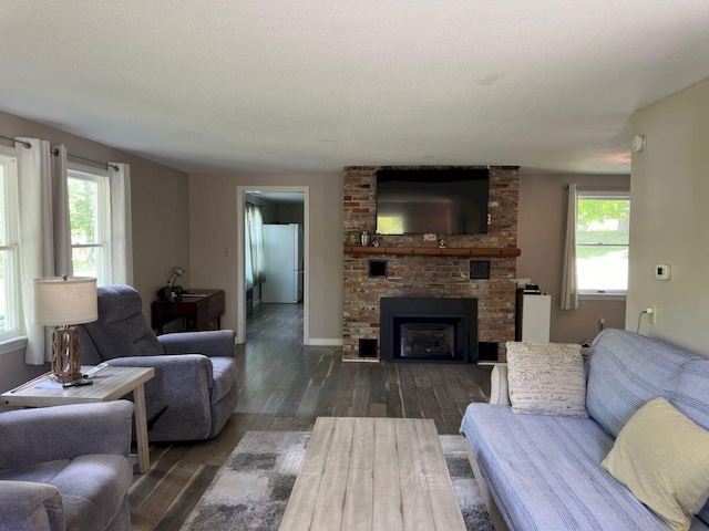 10 Research Dr, Skowhegan, ME 04976 - living area with dark wood-style flooring, plenty of natural light, a fireplace, and baseboards