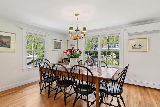 401 Princes Point Rd, Yarmouth, ME 04096 - dining area with a chandelier, ornamental molding, light wood finished floors, baseboards, and a wall mounted air conditioner