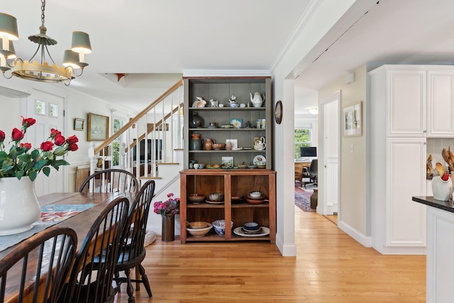 401 Princes Point Rd, Yarmouth, ME 04096 - dining room with a chandelier, light wood finished floors, stairs, crown molding, and baseboards