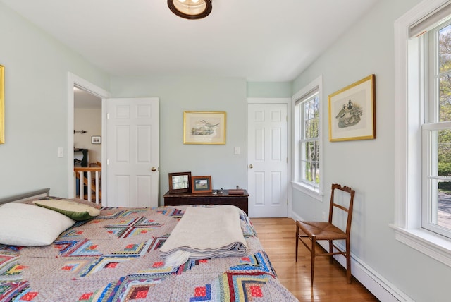 401 Princes Point Rd, Yarmouth, ME 04096 - bedroom with wood finished floors, multiple windows, baseboard heating, and baseboards