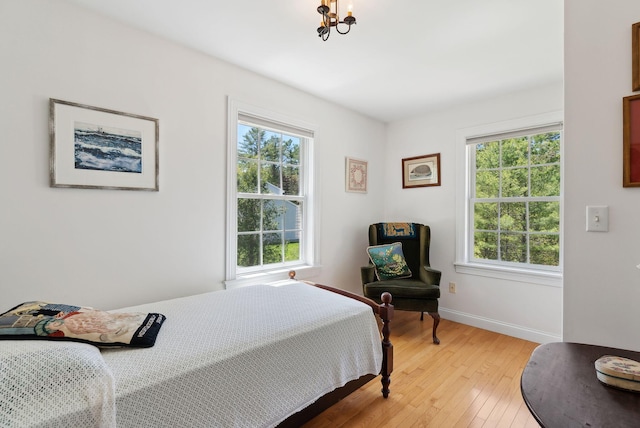 401 Princes Point Rd, Yarmouth, ME 04096 - bedroom featuring a chandelier, light wood-style flooring, and baseboards