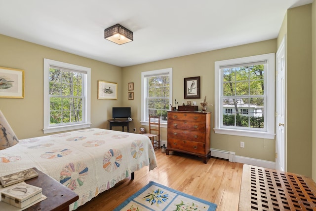 401 Princes Point Rd, Yarmouth, ME 04096 - bedroom with baseboard heating, wood finished floors, and baseboards