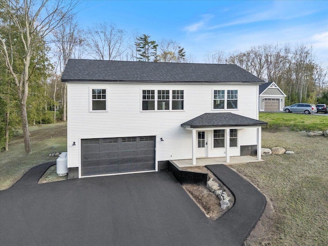 12 Casey Ln, Old Orchard Beach, ME 04064 - view of front of property featuring a garage, asphalt driveway, a front yard, and roof with shingles