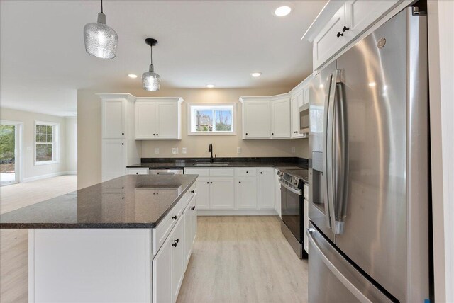 12 Casey Ln, Old Orchard Beach, ME 04064 - kitchen featuring stainless steel appliances, a sink, light wood-style floors, white cabinetry, and hanging light fixtures