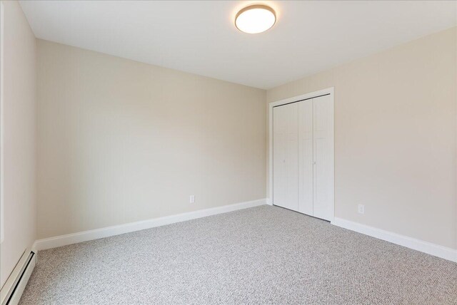 12 Casey Ln, Old Orchard Beach, ME 04064 - unfurnished bedroom with baseboard heating, carpet flooring, a closet, and baseboards