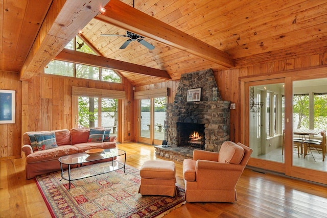 85 Provost Rd, Jefferson, ME 04348 - living room with wooden walls, a fireplace, wood-type flooring, wood ceiling with exposed beams, and ceiling fan