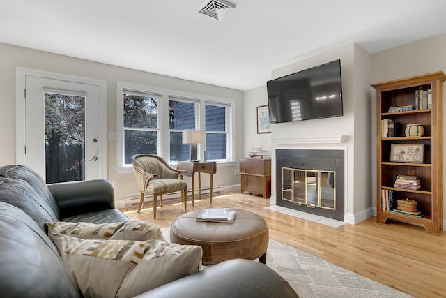 65 Pine Point Rd Unit 12, Scarborough, ME 04074 - living room featuring baseboard heating, a fireplace with flush hearth, light wood finished floors, and baseboards
