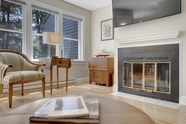 65 Pine Point Rd Unit 12, Scarborough, ME 04074 - sitting room featuring a fireplace with flush hearth, wood finished floors, baseboards, and a baseboard heating unit