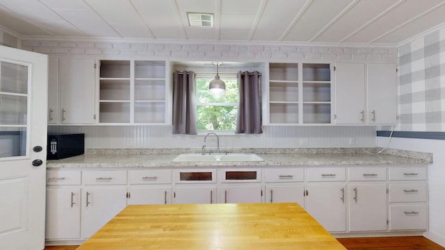 118 Riverside Dr, Auburn, ME 04210 - kitchen featuring open shelves, a sink, crown molding, black microwave, and white cabinets