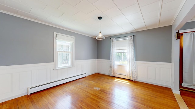 118 Riverside Dr, Auburn, ME 04210 - empty room with a baseboard radiator, plenty of natural light, a wainscoted wall, ornamental molding, and light wood-style floors