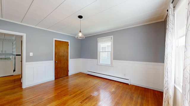 118 Riverside Dr, Auburn, ME 04210 - empty room featuring a baseboard radiator, light wood-style flooring, crown molding, and a wainscoted wall