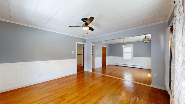 118 Riverside Dr, Auburn, ME 04210 - empty room with a baseboard radiator, crown molding, light wood-style flooring, ceiling fan, and a wainscoted wall