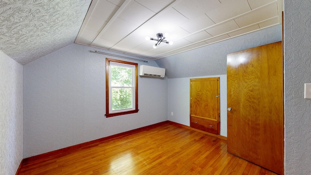 118 Riverside Dr, Auburn, ME 04210 - bonus room with a wall unit AC, lofted ceiling, wood finished floors, baseboards, and a textured ceiling