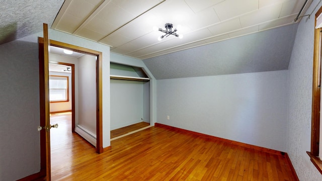 118 Riverside Dr, Auburn, ME 04210 - additional living space featuring baseboard heating, light wood-style flooring, lofted ceiling, and baseboards
