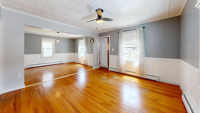 118 Riverside Dr, Auburn, ME 04210 - spare room with a baseboard radiator, crown molding, a wainscoted wall, ceiling fan, and light wood-style floors