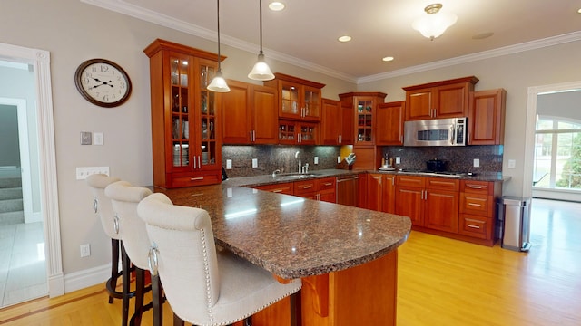 67 Joans Hill Rd, Bangor, ME 04401 - kitchen with stainless steel appliances, a sink, light wood-style floors, pendant lighting, and backsplash