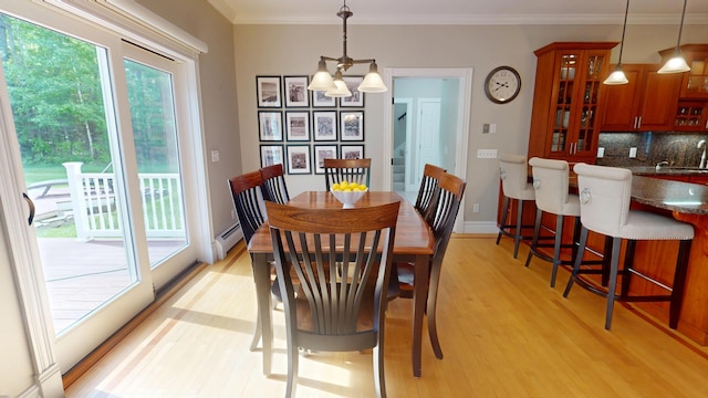 67 Joans Hill Rd, Bangor, ME 04401 - dining room with light wood-style flooring, a chandelier, a baseboard heating unit, ornamental molding, and baseboards