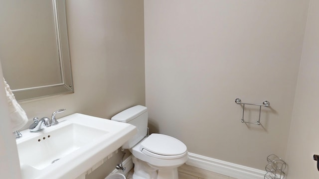 67 Joans Hill Rd, Bangor, ME 04401 - half bathroom featuring toilet, a sink, and baseboards