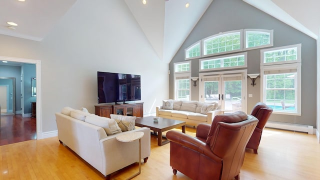 67 Joans Hill Rd, Bangor, ME 04401 - living area with baseboard heating, high vaulted ceiling, light wood-style flooring, plenty of natural light, and french doors