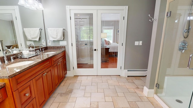 67 Joans Hill Rd, Bangor, ME 04401 - bathroom featuring french doors, a baseboard heating unit, a stall shower, double vanity, and stone finish floors