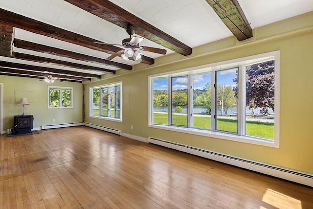 95 Riverview Dr, Gardiner, ME 04345 - unfurnished living room with ceiling fan, beam ceiling, a baseboard heating unit, a wood stove, and hardwood / wood-style floors
