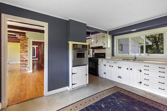 95 Riverview Dr, Gardiner, ME 04345 - kitchen with wall oven, black gas stove, a sink, white cabinets, and baseboards