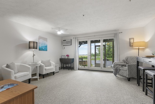 1801 Post Rd Unit 144, Wells, ME 04090 - living area featuring a textured ceiling, carpet flooring, a wall mounted AC, and a ceiling fan
