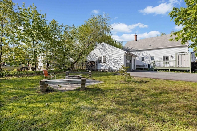 1 Fall St, Biddeford, ME 04005 - view of green lawn featuring an outdoor fire pit, a wooden deck, and asphalt driveway
