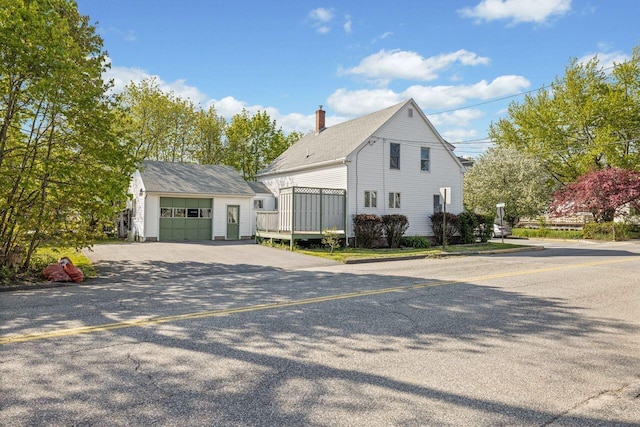 1 Fall St, Biddeford, ME 04005 - view of side of home featuring an outdoor structure, a chimney, driveway, and a garage