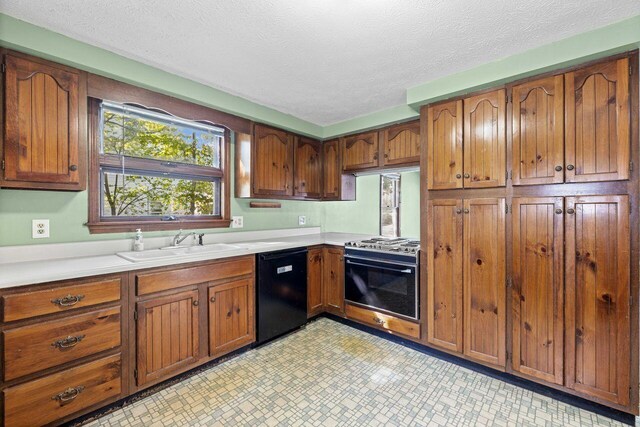 1 Fall St, Biddeford, ME 04005 - kitchen featuring black dishwasher, range with gas stovetop, a sink, light countertops, and brown cabinets