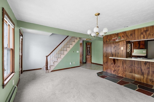 1 Fall St, Biddeford, ME 04005 - unfurnished living room featuring a baseboard heating unit, a chandelier, carpet flooring, stairs, and a textured ceiling