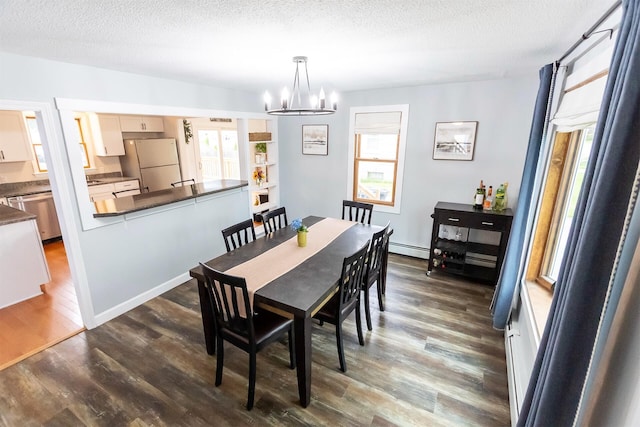 22 Penn Ave, Portland, ME 04103 - dining area featuring a baseboard radiator, a chandelier, dark wood finished floors, and a textured ceiling