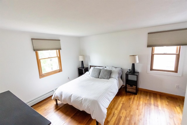 22 Penn Ave, Portland, ME 04103 - bedroom featuring a baseboard heating unit, multiple windows, and light wood-type flooring