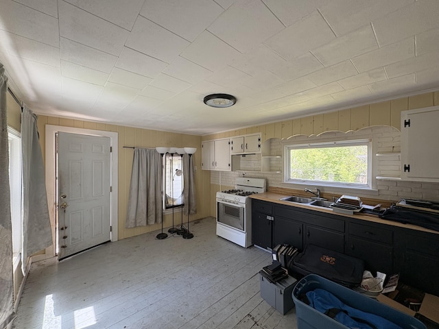 66 Pleasant St, Passadumkeag, ME 04461 - kitchen featuring white range with gas cooktop, a sink, light wood-type flooring, light countertops, and white cabinets