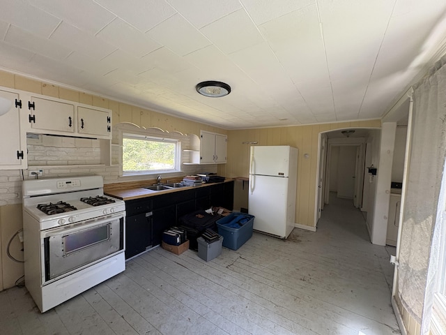 66 Pleasant St, Passadumkeag, ME 04461 - kitchen featuring white appliances, a sink, light wood-style flooring, white cabinets, and wood walls