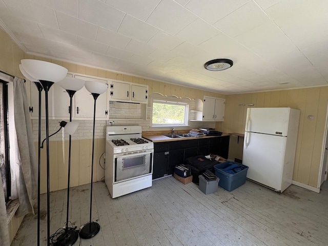 66 Pleasant St, Passadumkeag, ME 04461 - kitchen with white appliances, a sink, light wood finished floors, wood walls, and white cabinets