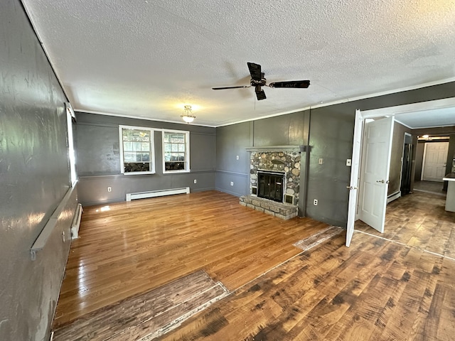 5 Grant Rd, Saint Albans, ME 04971 - unfurnished living room with baseboard heating, ceiling fan, a textured ceiling, wood finished floors, and a fireplace
