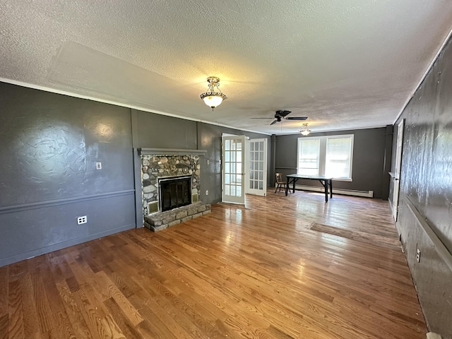 5 Grant Rd, Saint Albans, ME 04971 - unfurnished living room featuring a textured ceiling, a ceiling fan, wood finished floors, a fireplace, and baseboards