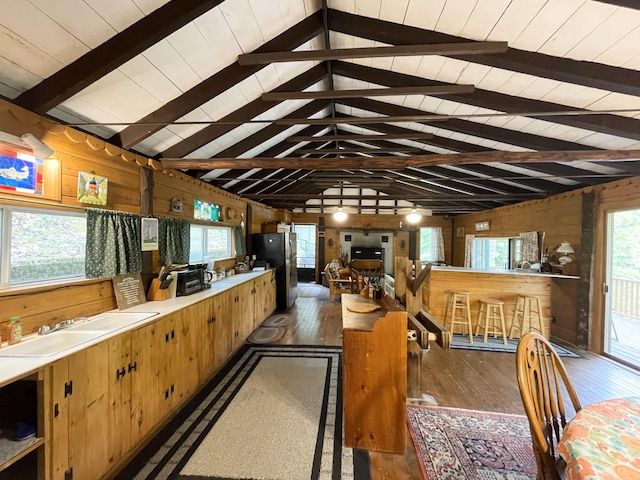 55 Sandy Bottom Rd, Turner, ME 04282 - kitchen with wood walls, freestanding refrigerator, hardwood / wood-style floors, a sink, and light countertops