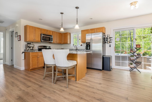 13 Daggett St, Portland, ME 04103 - kitchen with stainless steel appliances, light wood-type flooring, a breakfast bar, a center island, and recessed lighting
