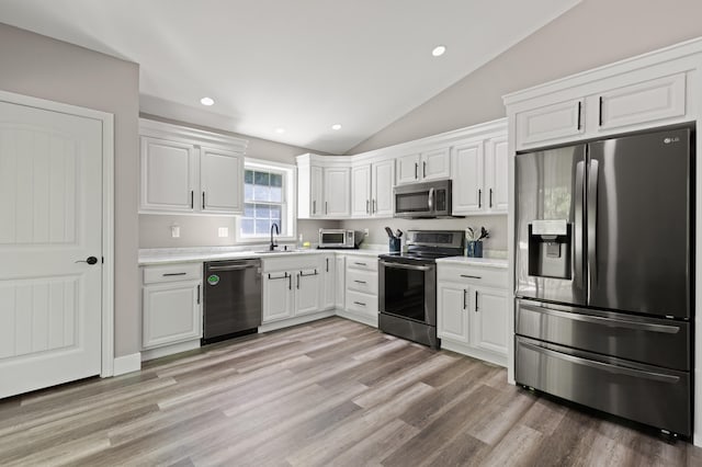 186 Yarmouth Rd, Gray, ME 04039 - kitchen featuring appliances with stainless steel finishes, lofted ceiling, light countertops, white cabinets, and recessed lighting