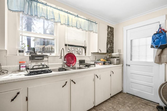 6 Winter St, Augusta, ME 04330 - kitchen with light countertops, backsplash, white cabinets, ornamental molding, and plenty of natural light