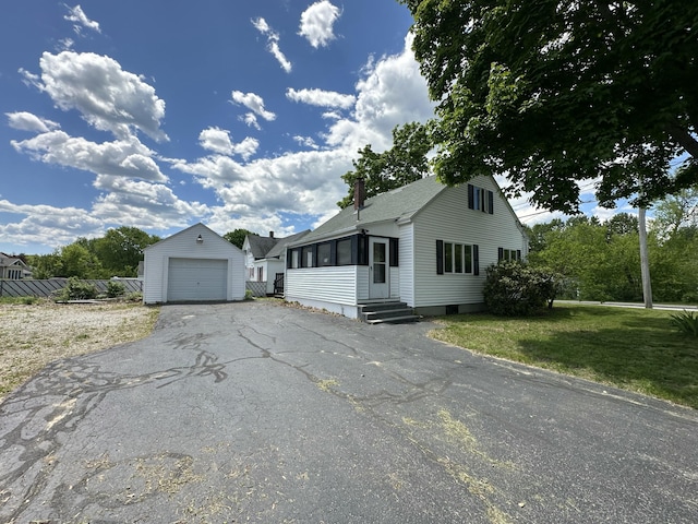 52 Rideout Ave, Lewiston, ME 04240 - view of front facade with an outdoor structure, entry steps, a detached garage, asphalt driveway, and a chimney