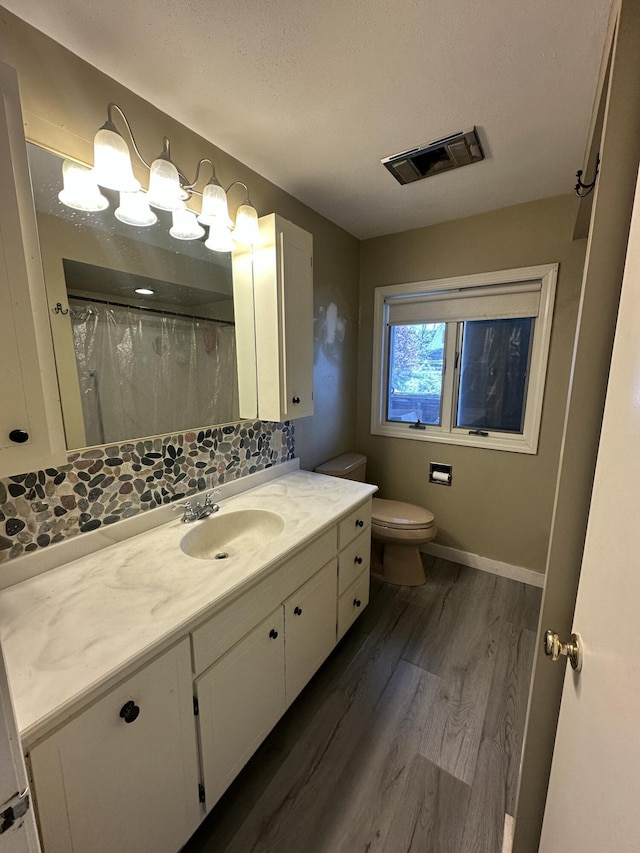 52 Rideout Ave, Lewiston, ME 04240 - bathroom with toilet, vanity, wood finished floors, decorative backsplash, and baseboards