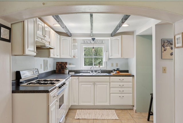592 Old Stage Rd, Arrowsic, ME 04530 - kitchen with white gas range, under cabinet range hood, dark countertops, a sink, and white cabinets