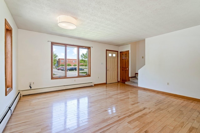 94 Thompson St, South Portland, ME 04106 - unfurnished room with light wood-style floors, stairway, a textured ceiling, baseboards, and baseboard heating