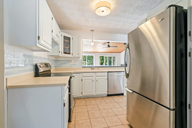 94 Thompson St, South Portland, ME 04106 - kitchen with stainless steel appliances, a ceiling fan, a sink, light countertops, and a textured ceiling