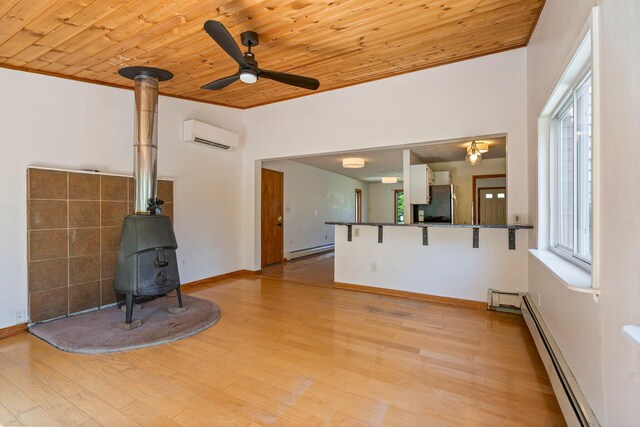 94 Thompson St, South Portland, ME 04106 - unfurnished living room with a wood stove, a baseboard radiator, wood ceiling, an AC wall unit, and ceiling fan