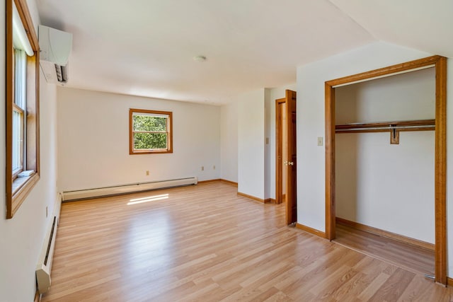 94 Thompson St, South Portland, ME 04106 - unfurnished bedroom featuring a baseboard radiator, a wall mounted air conditioner, light wood-style floors, baseboards, and a closet